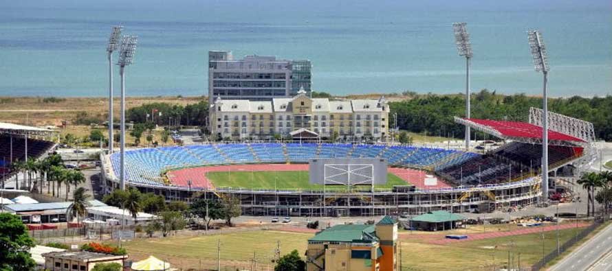 Exterior view of a large sports stadium with tiered stands under a blue sky.