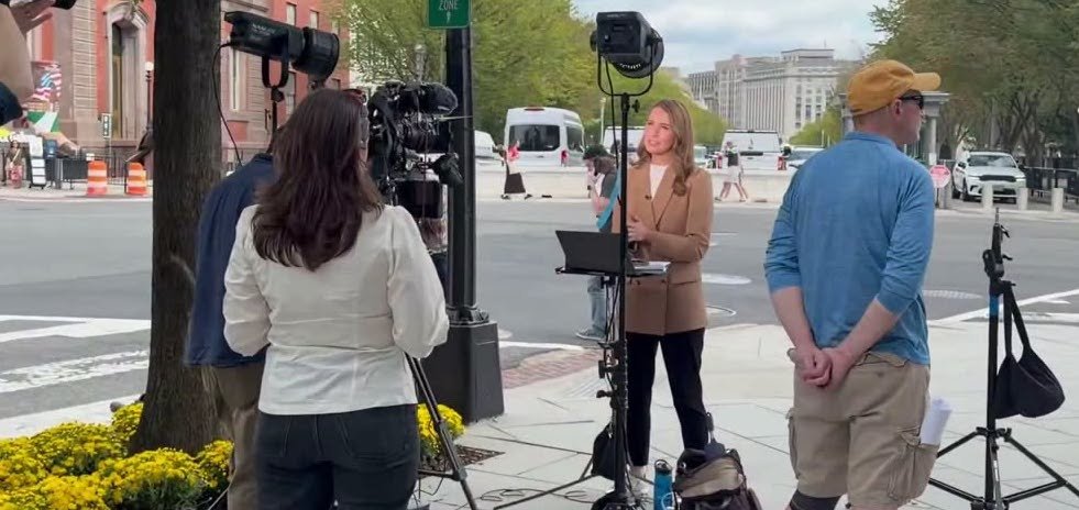 Television journalists report from outside the White House during a dispute over press access.