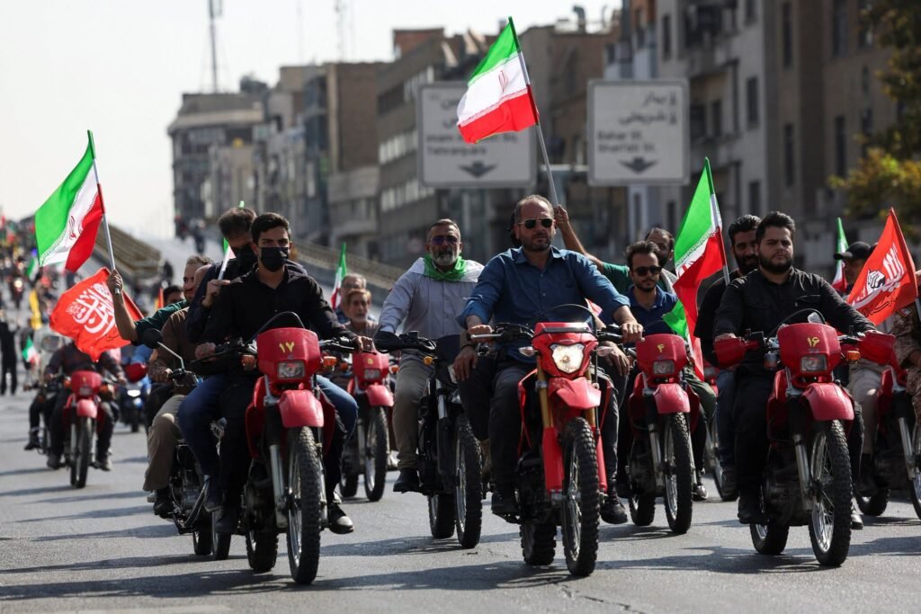 People ride motorcycles through a street during a public demonstration in Tehran.