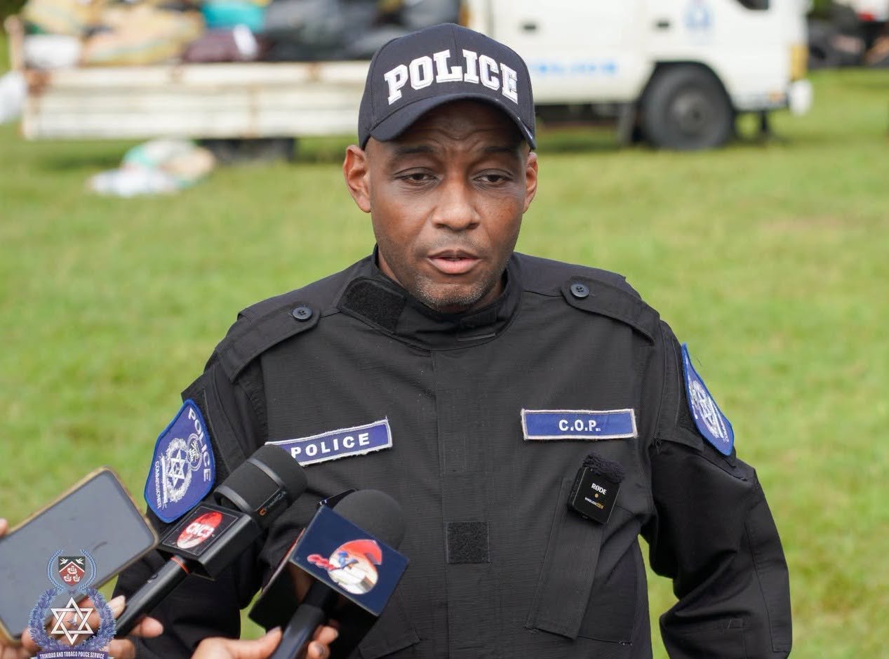 A uniformed police commissioner speaks into microphones during an outdoor press briefing.