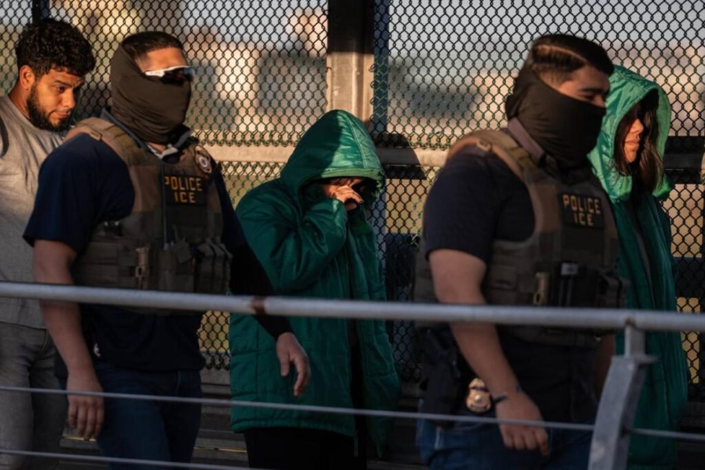 Law enforcement officers stand near a pedestrian bridge crossing at a U.S. border checkpoint.