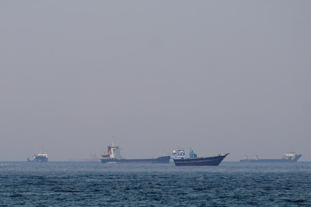 Commercial ships traveling through the Strait of Hormuz.