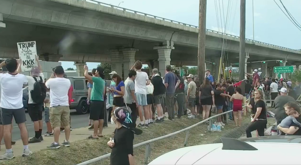 Protesters gather near an Austin street where an ICE officer shot and wounded a man.