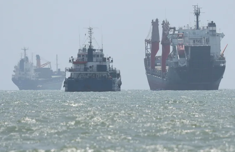 Commercial ships traveling through the Strait of Hormuz between Iran and Oman.