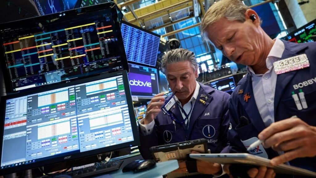 Trader watching financial-market data on computer screens.