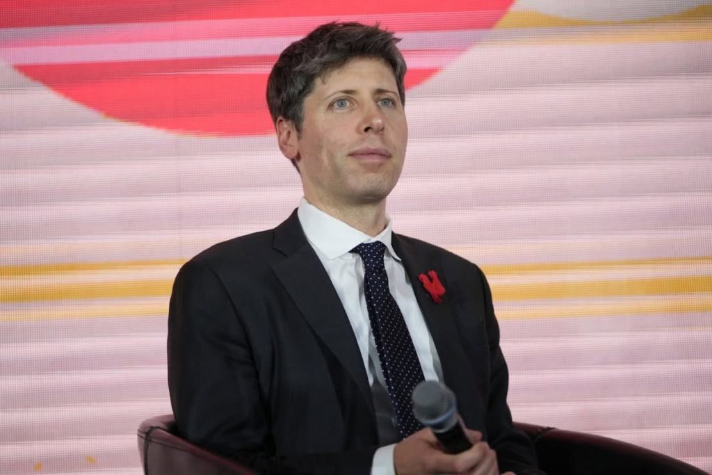 A man in business attire speaks at a podium or on a conference stage.