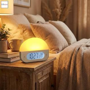 A sunrise alarm clock glowing softly on a wooden bedside table as early morning light enters the room.