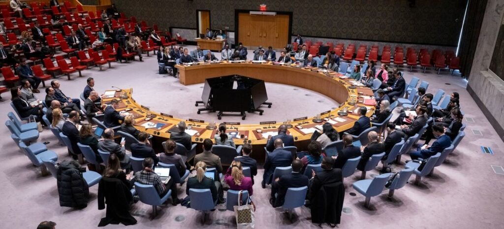 Delegates seated around the horseshoe-shaped table in the United Nations Security Council chamber.