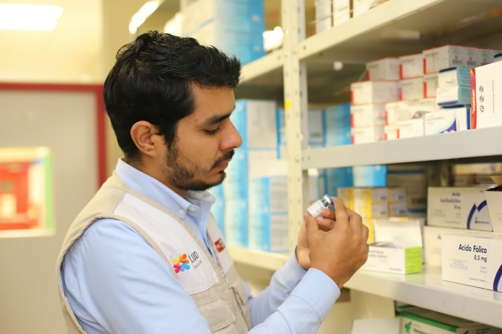 A pharmacist  reads the label on a prescription medication bottle.
