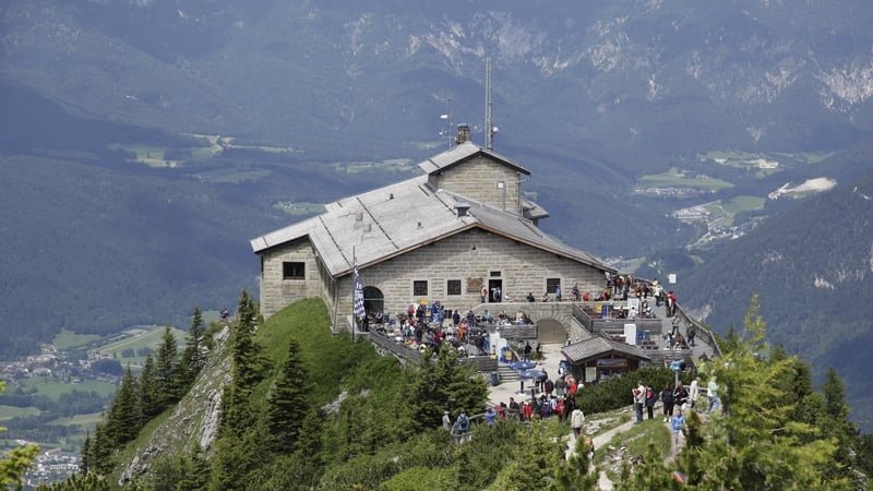 A stone building on a mountain peak under a blue sky.