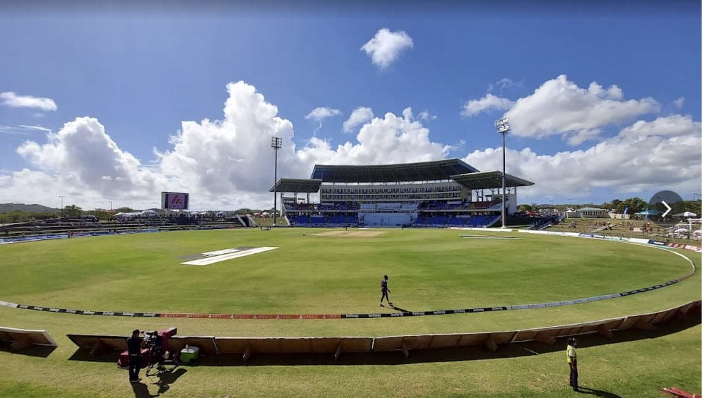 A cricket stadium in Antigua with a green outfield and stands.