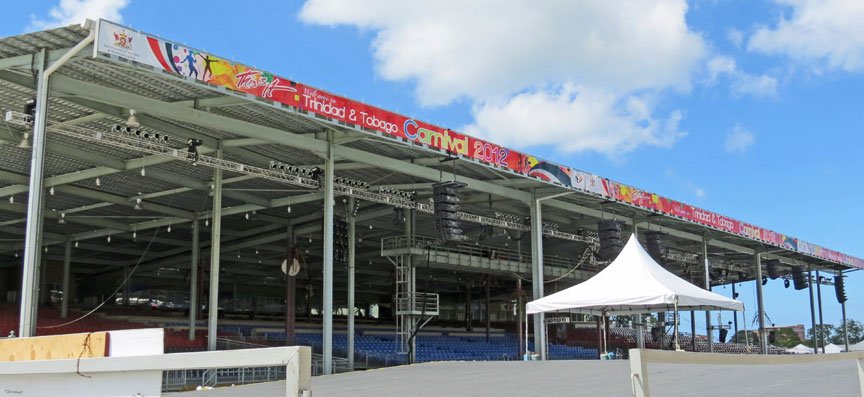 A large grandstand at the edge of a grassy savannah in Port of Spain.