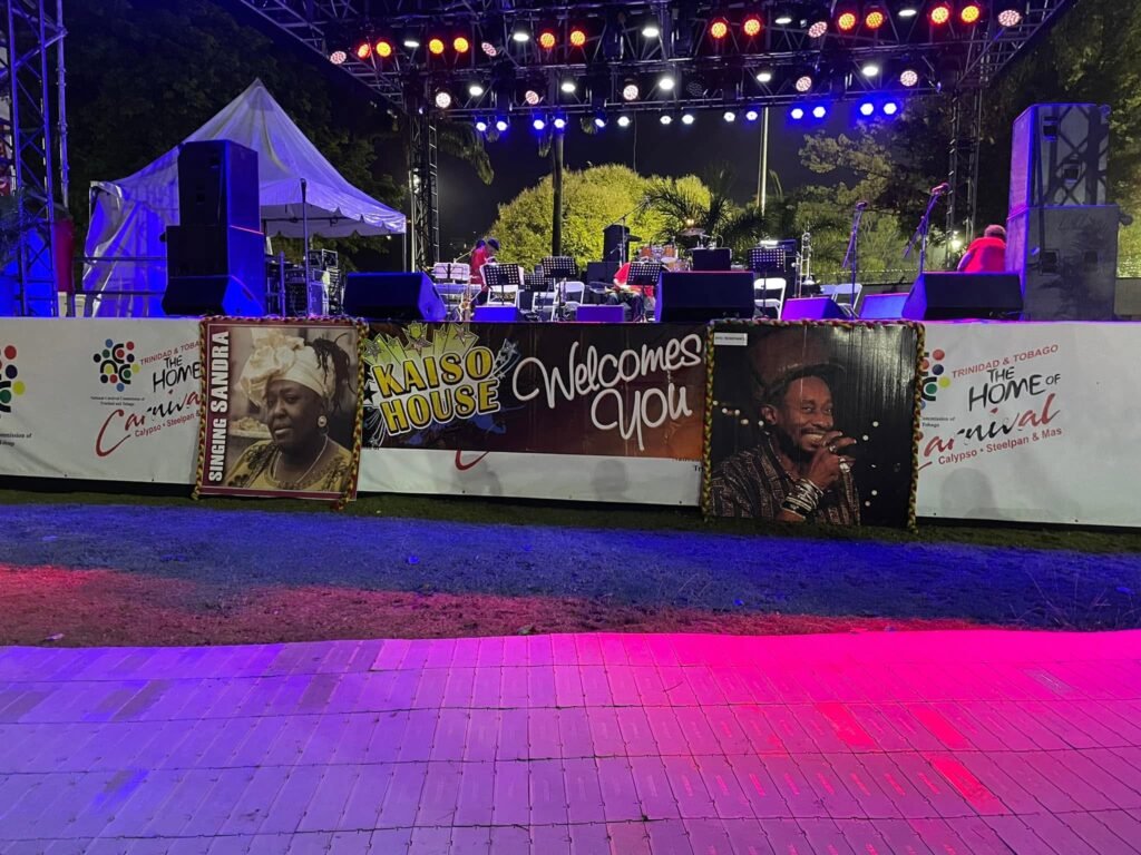 A stage with a microphone and a banner at a calypso tent.