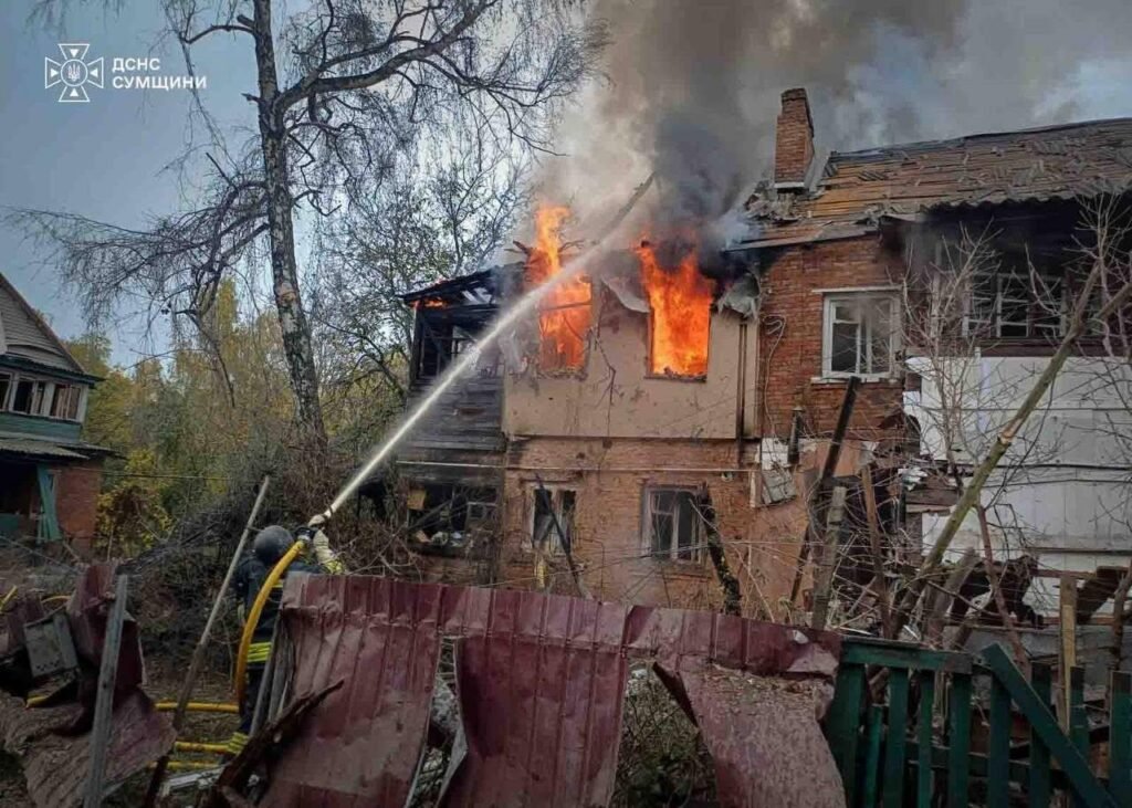 Damaged houses with broken roofs and debris after an air strike in a residential street.