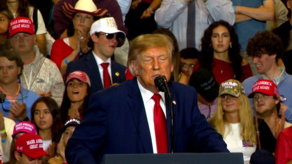 President Donald Trump speaking at a podium with a microphone.