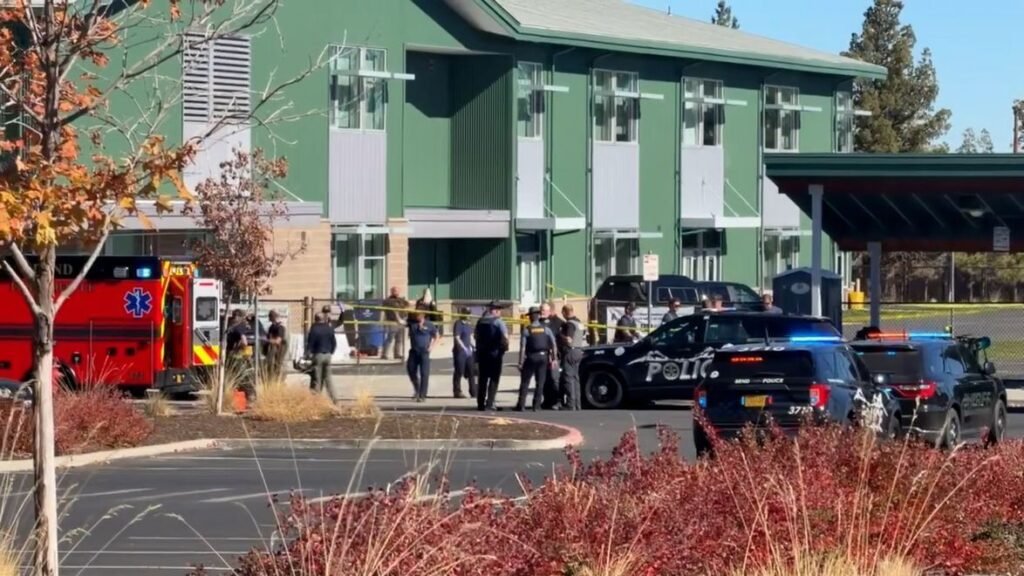 A one-story elementary school building with a police vehicle parked in front.