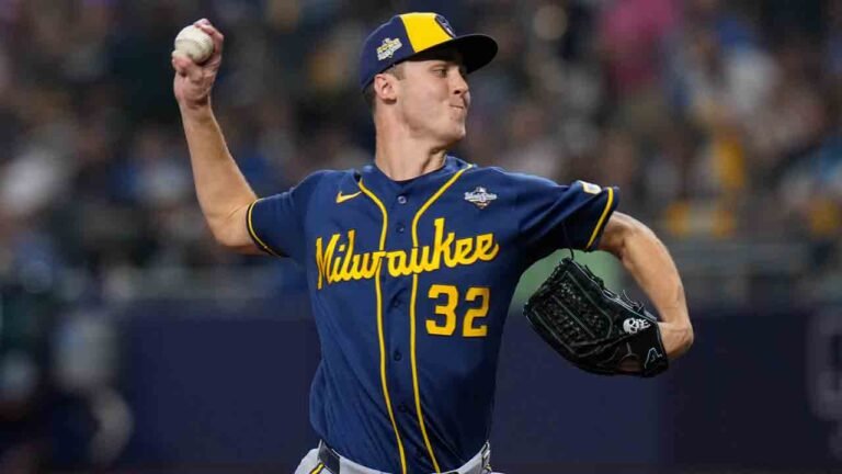 A pitcher in a gray road uniform in his delivery.