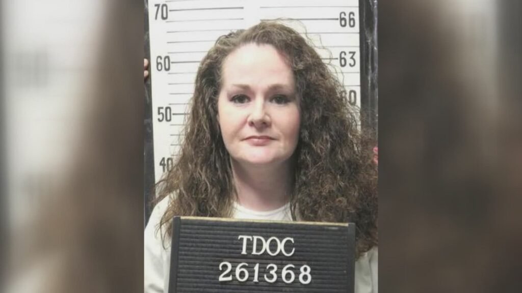 A booking photo of a woman with a serious expression.
