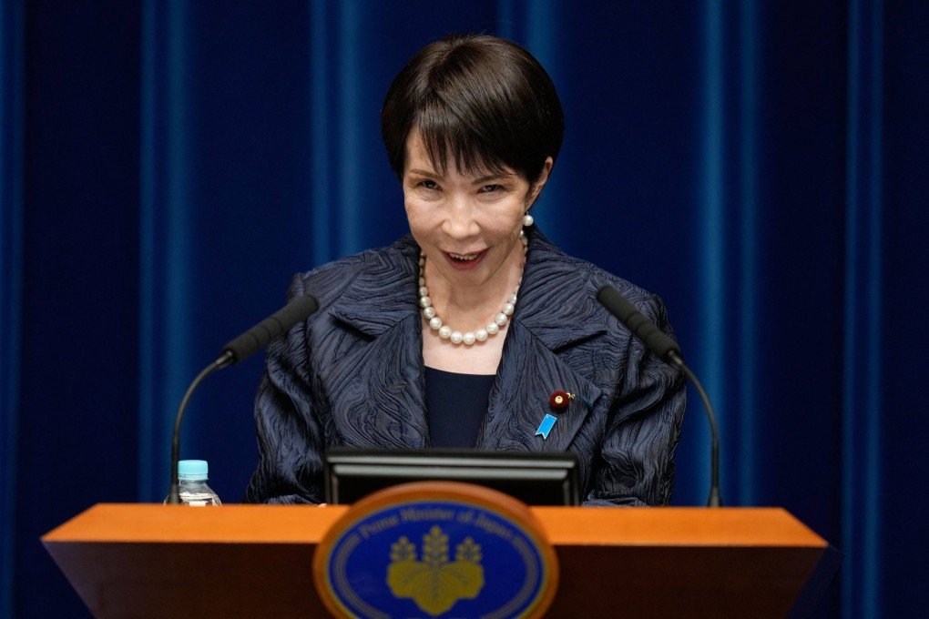A woman in formal attire speaks at a podium during a press briefing.