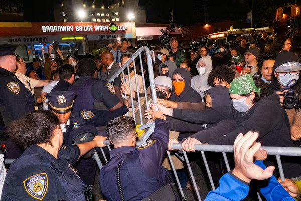 Protesters and police officers pushing against each other on a New York City street.
