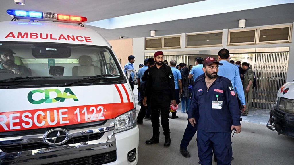Ambulances parked outside the entrance of a large hospital building in Peshawar.