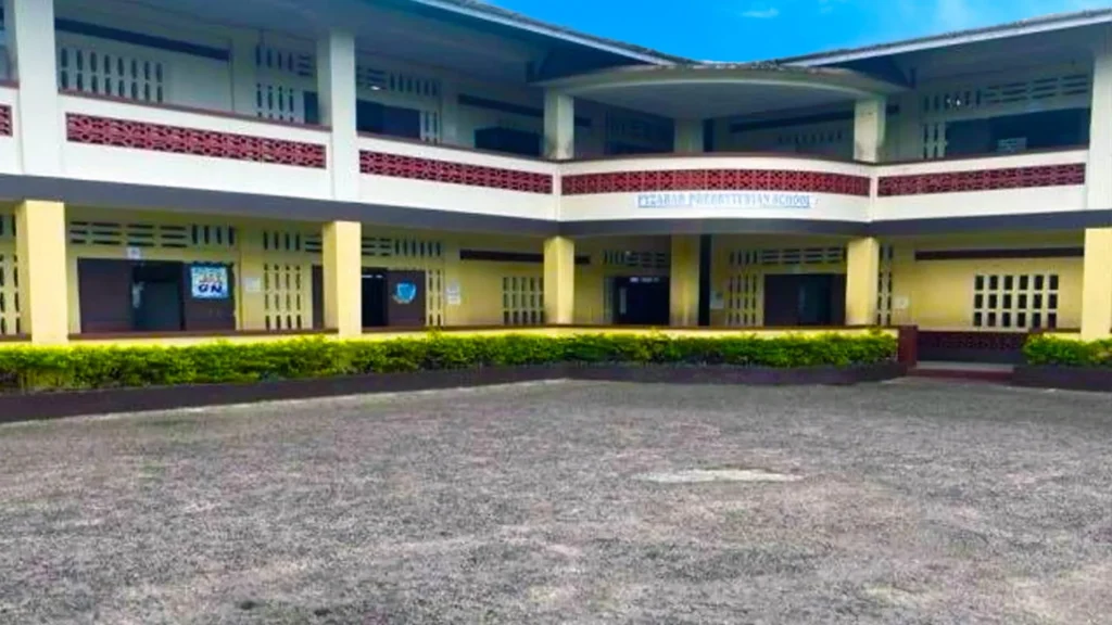 The entrance of a primary school in Fyzabad with a school sign.