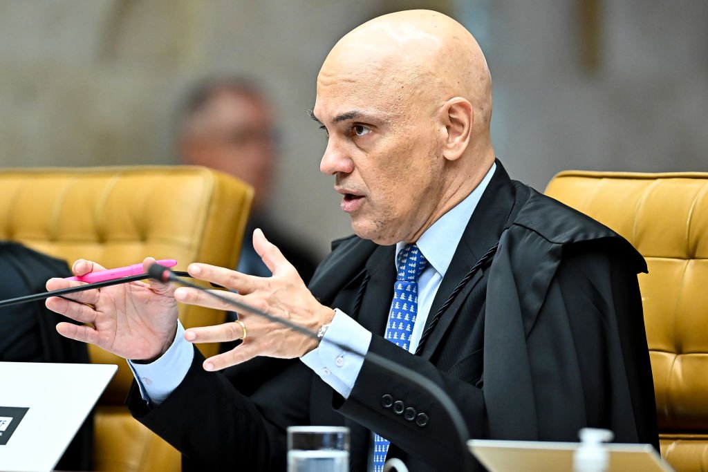 A judge in a black robe seated in the Supreme Court chamber.