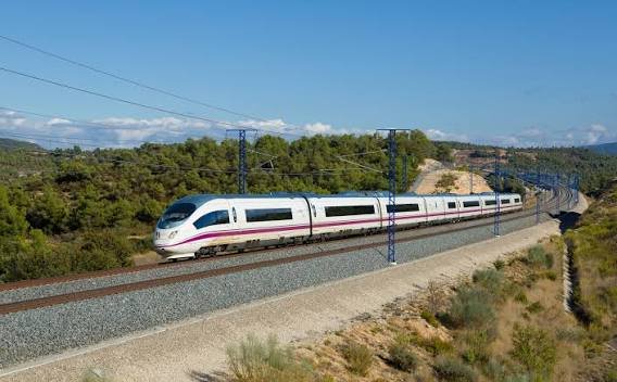 A red and white high-speed train on a straight track.