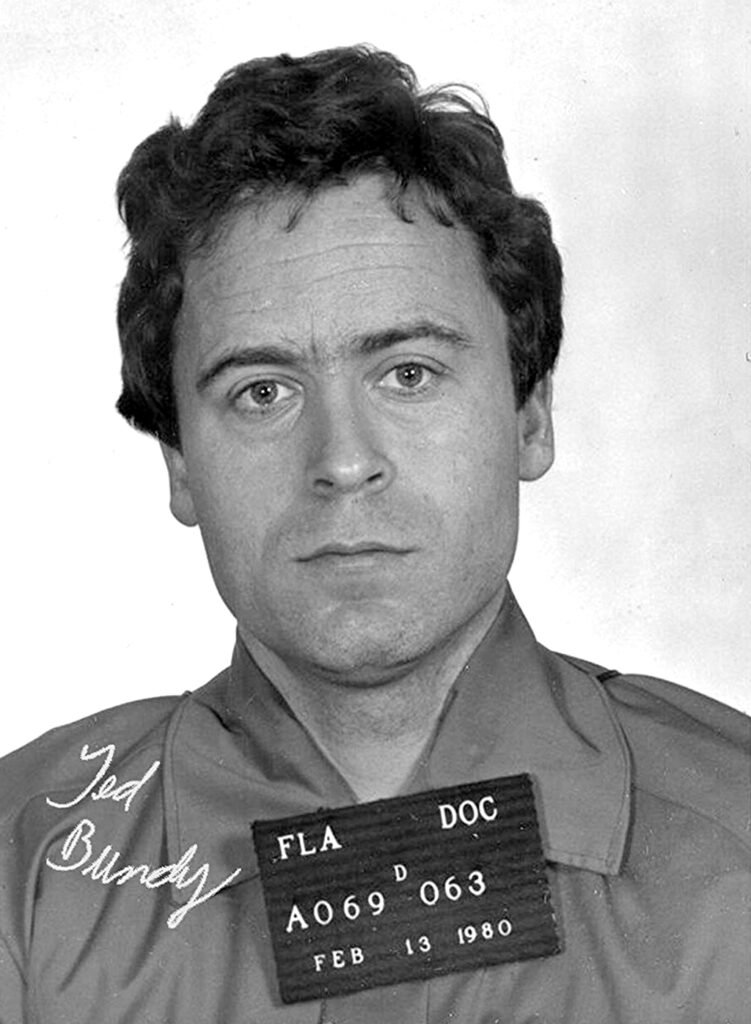 A black-and-white mug shot of a man in a prison uniform.