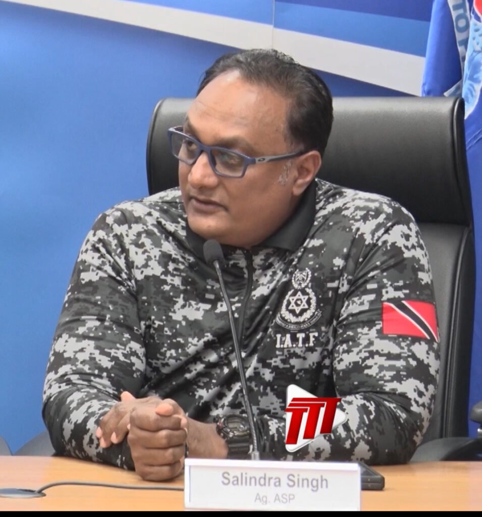 A uniformed police officer speaking at a media briefing.