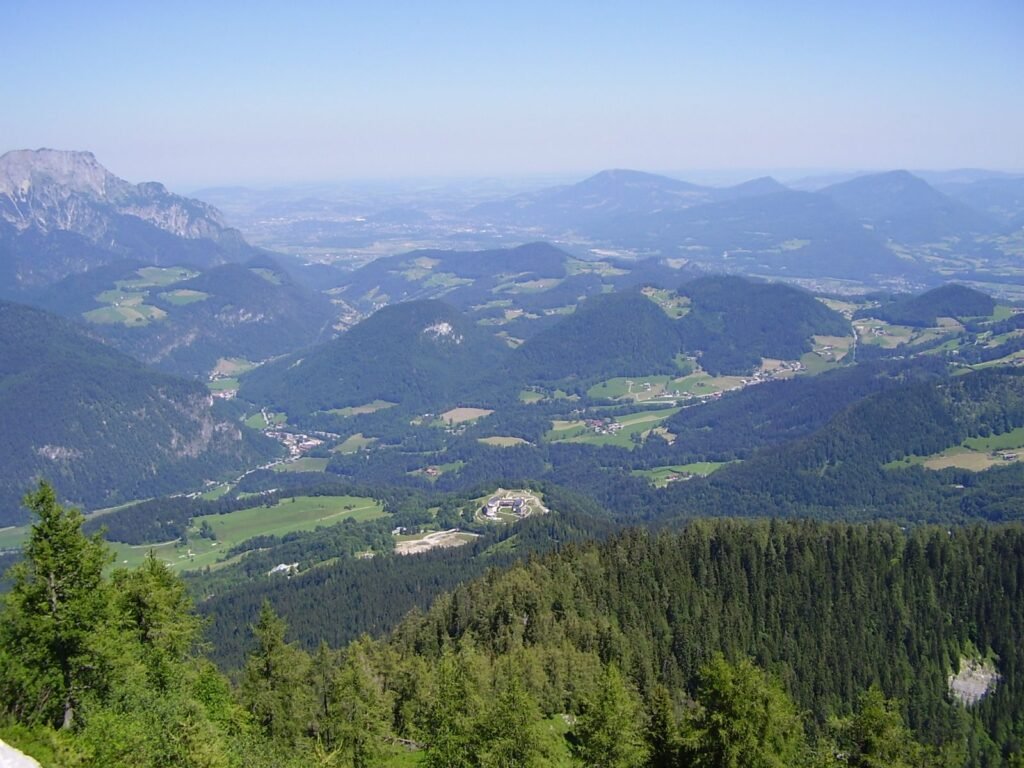 Snow-capped mountains above a green alpine valley.