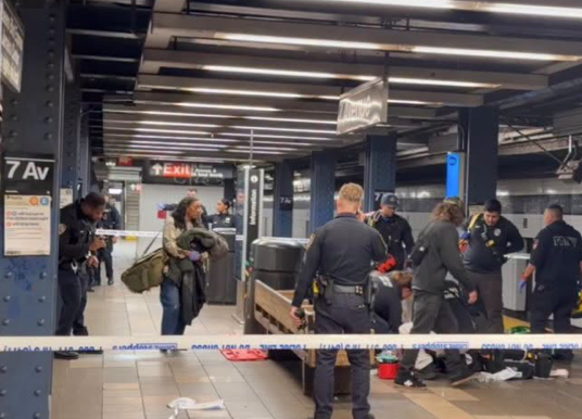 Police officers and emergency vehicles outside a subway station entrance in Midtown Manhattan.