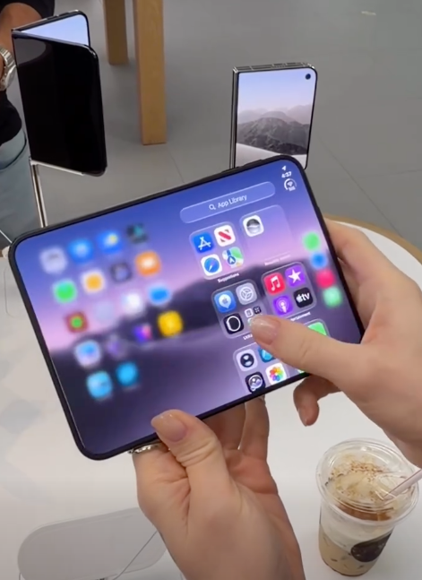 A customer holding a partially folded phone at a display table.