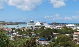 A view of St. John’s harbor in Antigua with buildings and boats under a blue sky.
