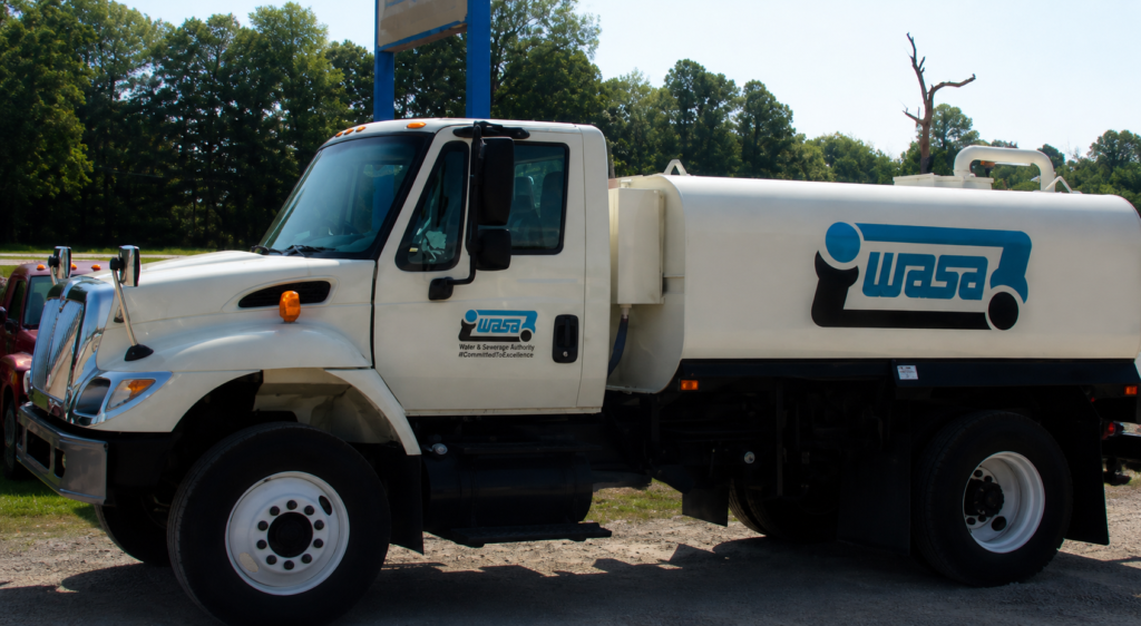 A water truck parked on a residential street in Trinidad.
