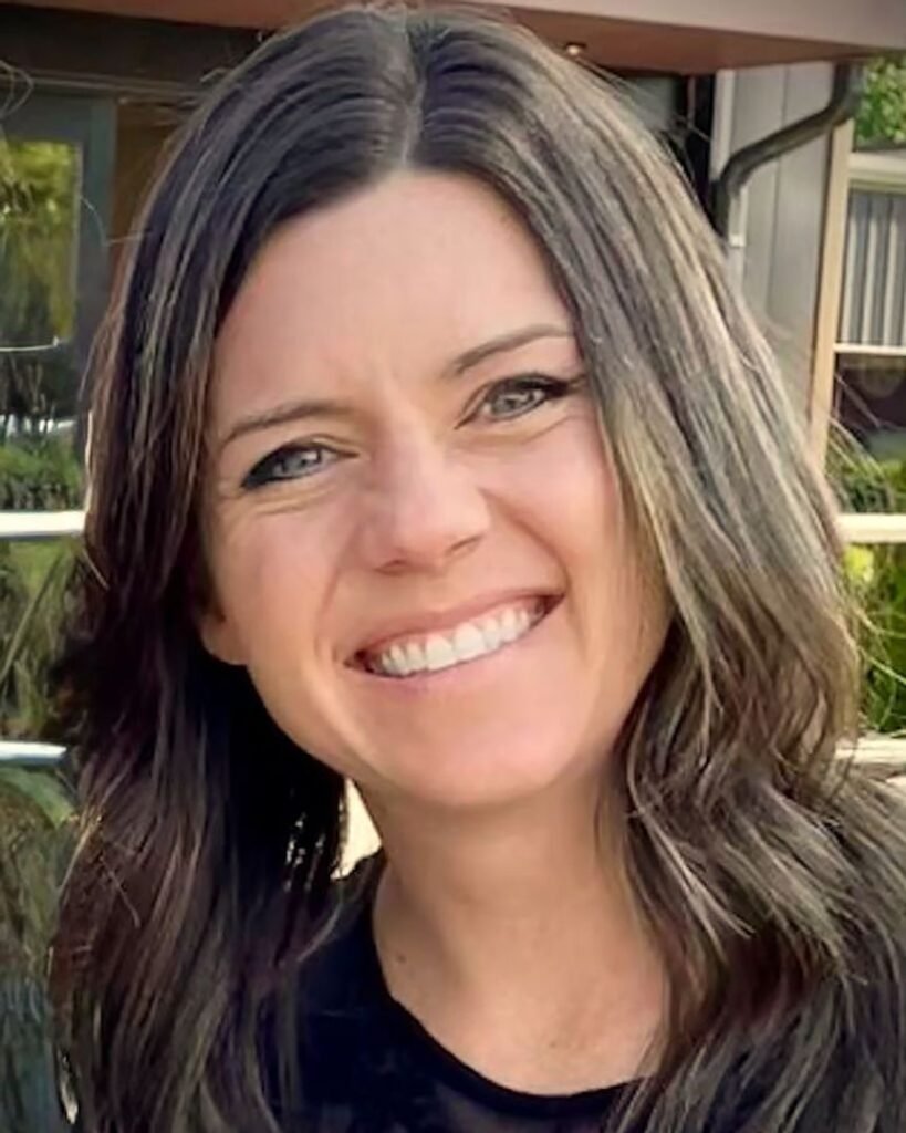 A woman smiles in a portrait photo.