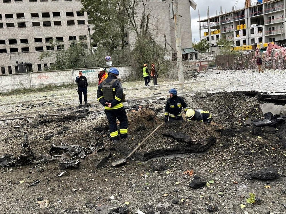 Rescuers working near a damaged apartment block in Ukraine.