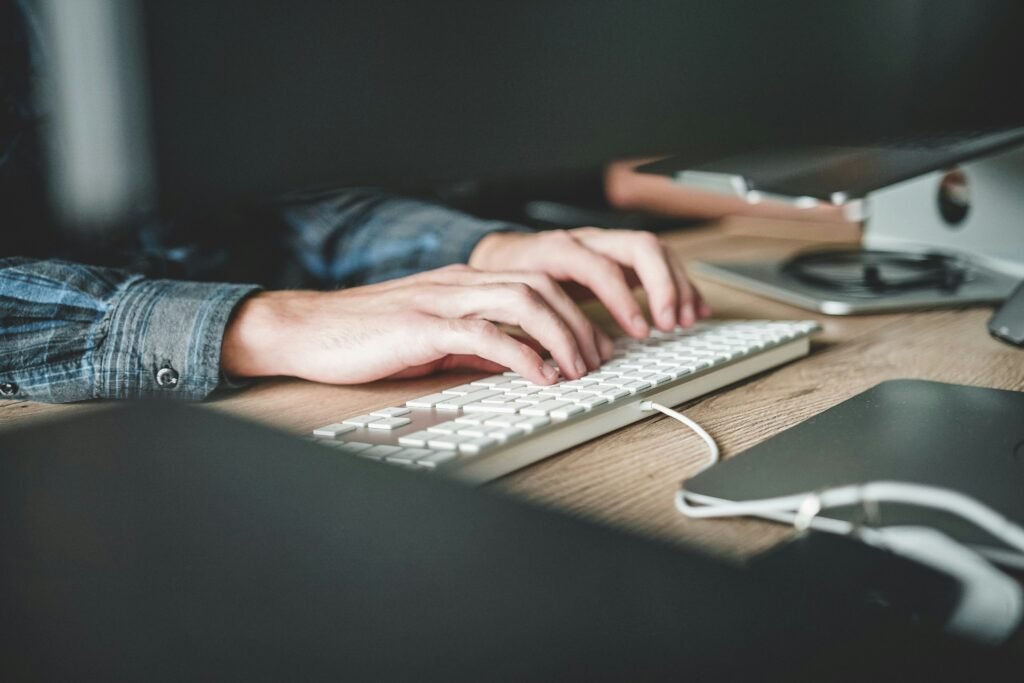 A person’s hands typing on a  keyboard.